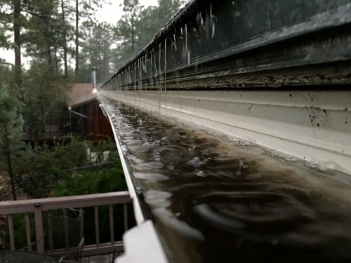 Clogged gutters in a rainstorm