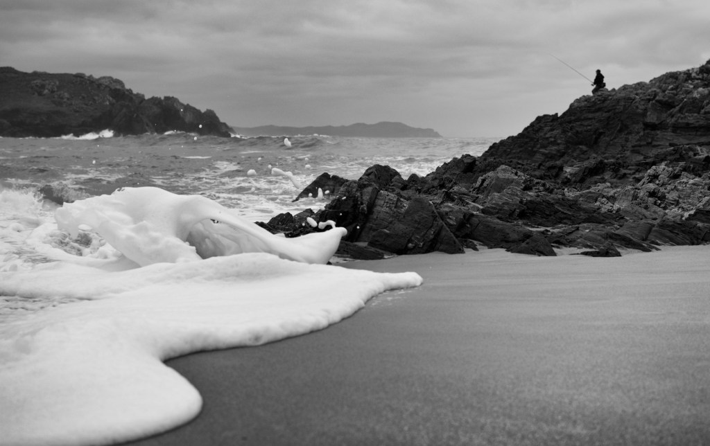 Foaming waves running amongst rocks on a beach