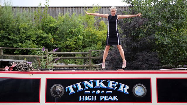 Author Jo Bell standing on top of her narrowboat 'Tinker'
